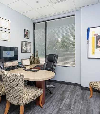 The consultation room, with a round table and patient photographs on the wall.
