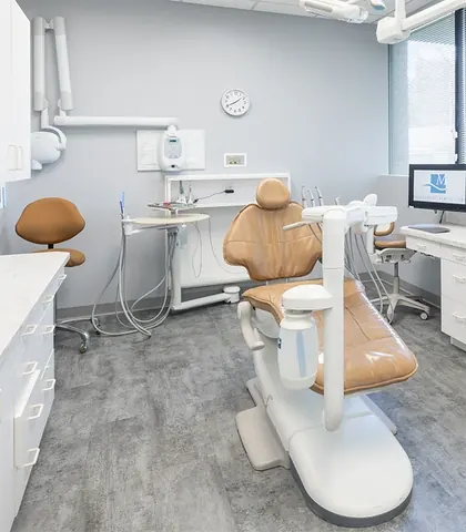 A treatment room with a full-width window and a view of the trees outside.