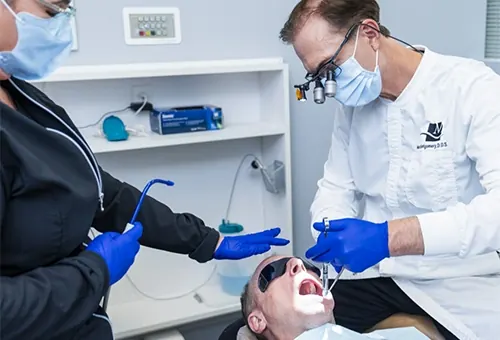 Dr. Montgomery and an assistant treating a patient.
