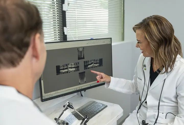 Dr. Wolken showing a patient his x-rays on the screen.